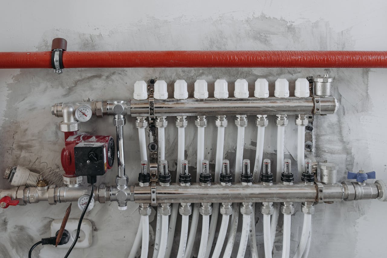 about-us-01 A close-up view of an industrial manifold with pressure gauges and connected steel pipes.